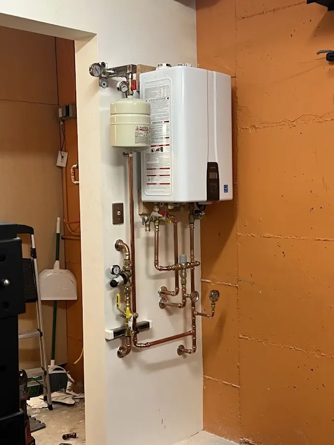 Plumbing technician inspecting water heater connections in Ardmore